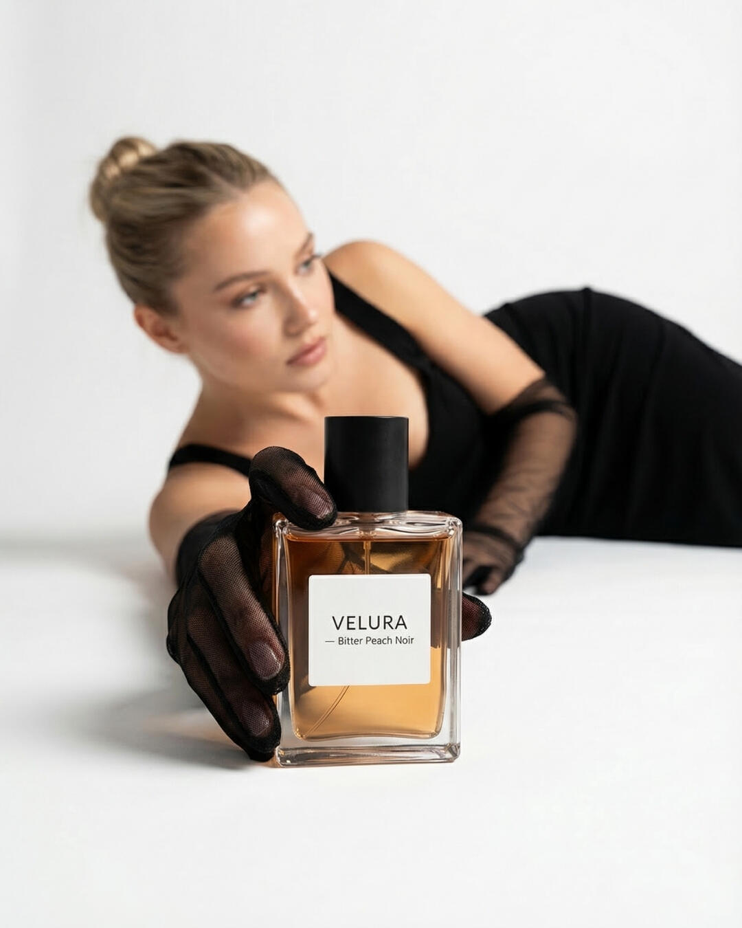 Untitled Studio editorial lookbook photography, featuring a model in a black dress and sheer mesh gloves presenting a mock perfume bottle design.